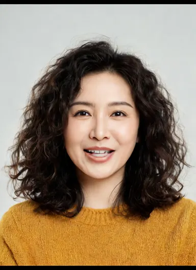 Studio portrait of a friendly woman in her 30s with curly dark hair, warm smile, mustard sweater, soft neutral backdrop, faci